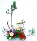 寿松,枝松,梅枝,南天の実,葉ボタンなどの花材を竹の器に活けたお年賀用のギフト フラワーアレンジです。